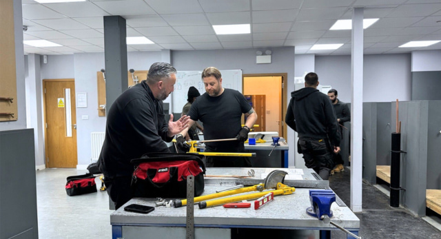 plumbing trainer helping a man retrain as a plumber