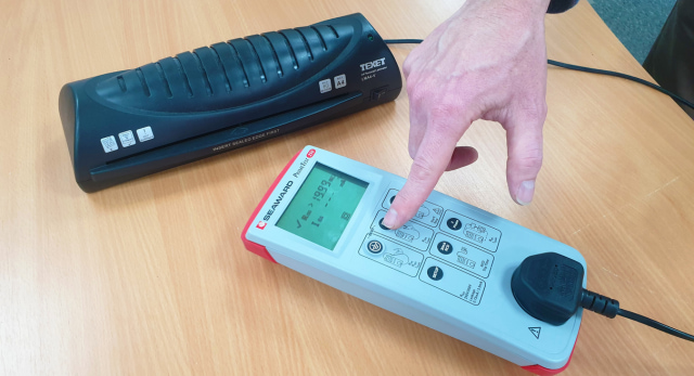 An electrical trainer explaining what PAT testing is whilst pointing to a tester