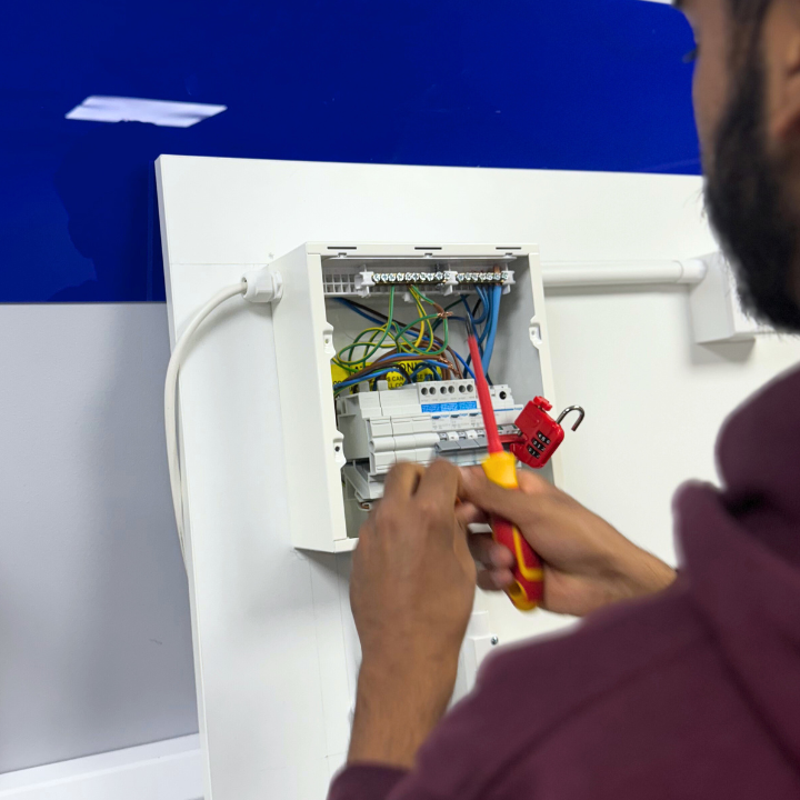 A Logic4training electrical student locking off as part of their safe electrical isolation training course