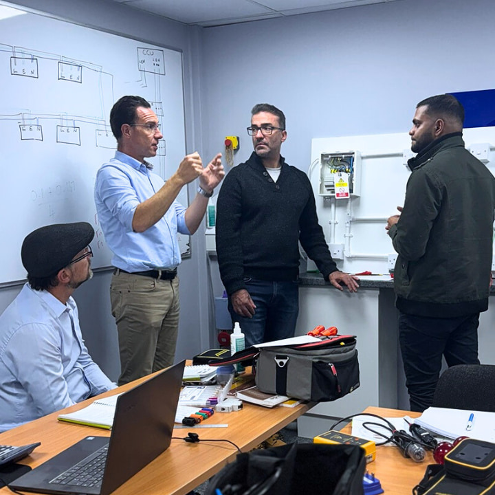 A Logic4training trainer with electrical students going through the 18th edition wiring regulations