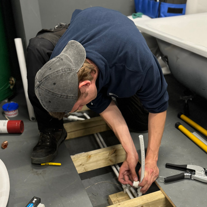A trainee plumber completing their training in accordance with the water regulations