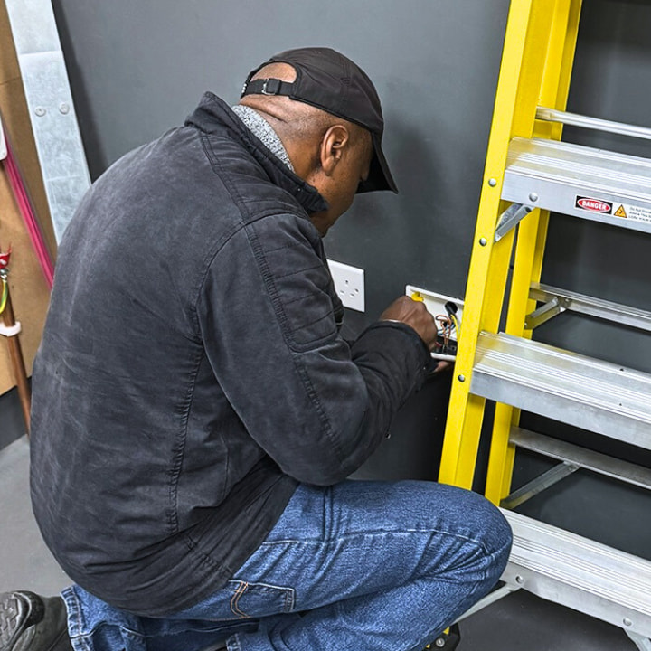 An electrician changing a switch and proving they have electrical experience