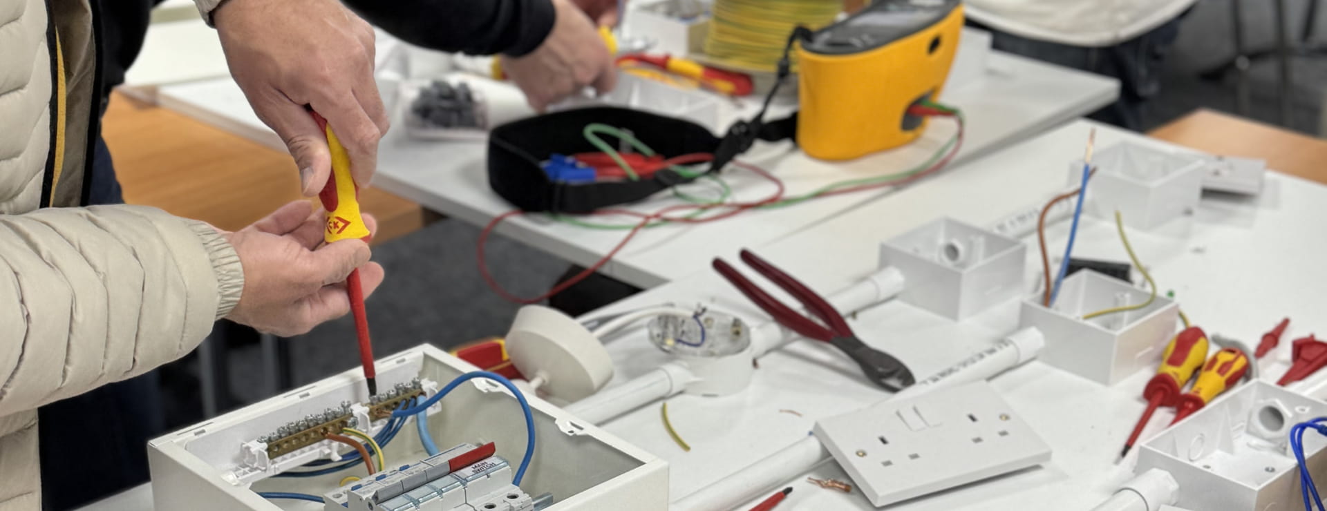 Electrical students working on electrical systems to learn and become an electrician
