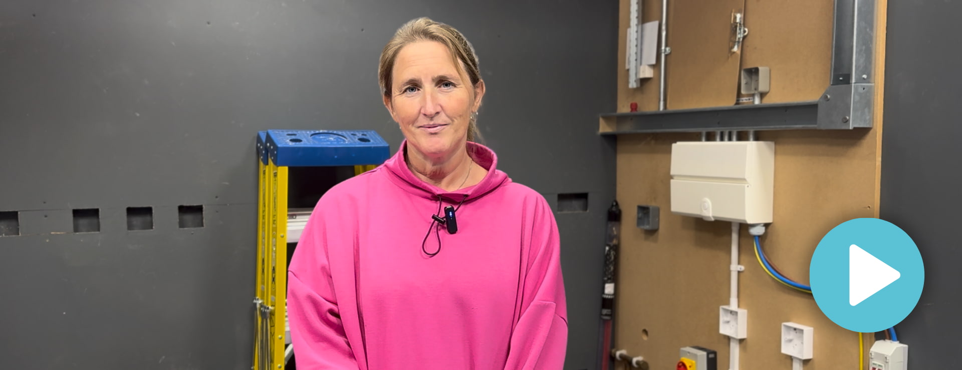 Headshot of Christine standing in the electrical workshop giving a testimonial about her career change and domestic electrical installer course