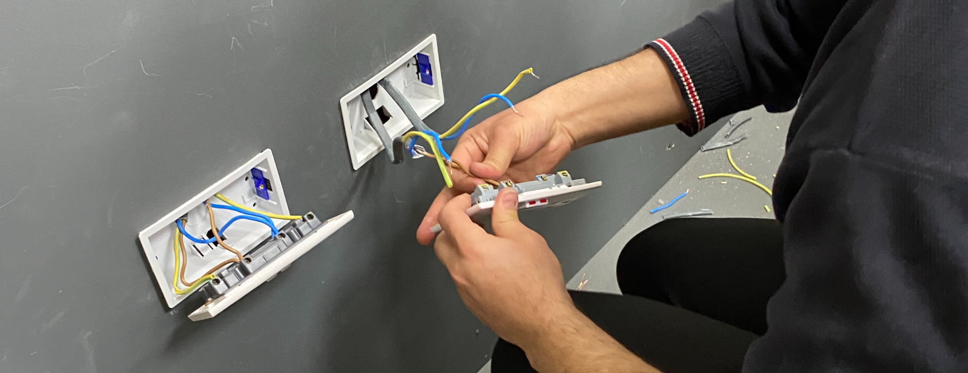 electrician working on a plug socket to earn money