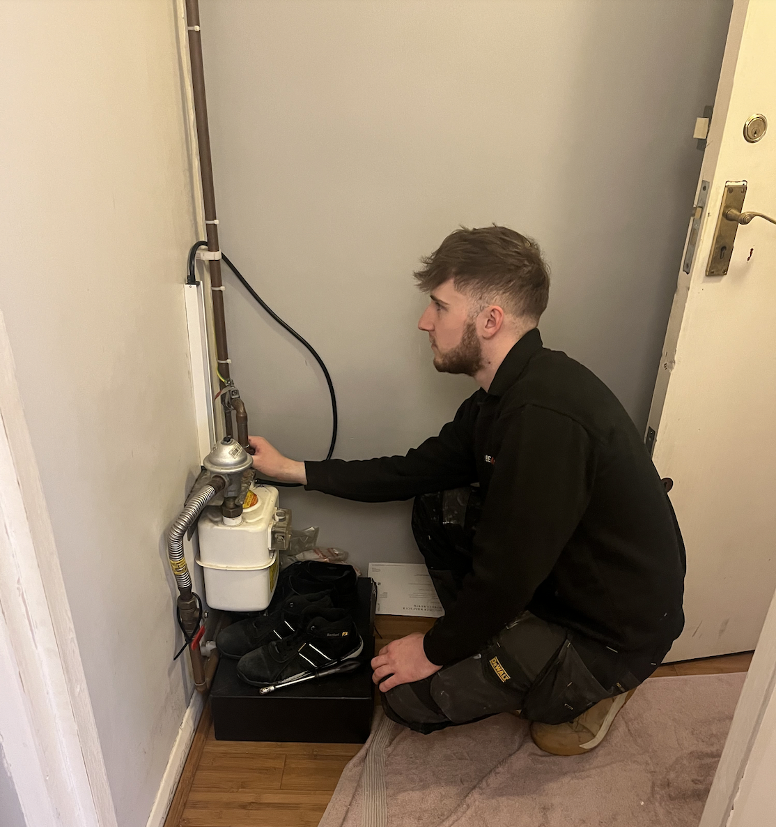 a white man performing a plumbing test while crouching