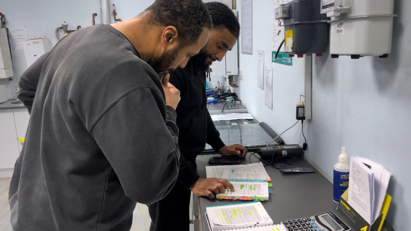 two gas students reading the training manual