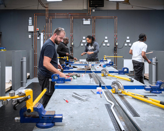 a group of plumbing diploma students in the workshop