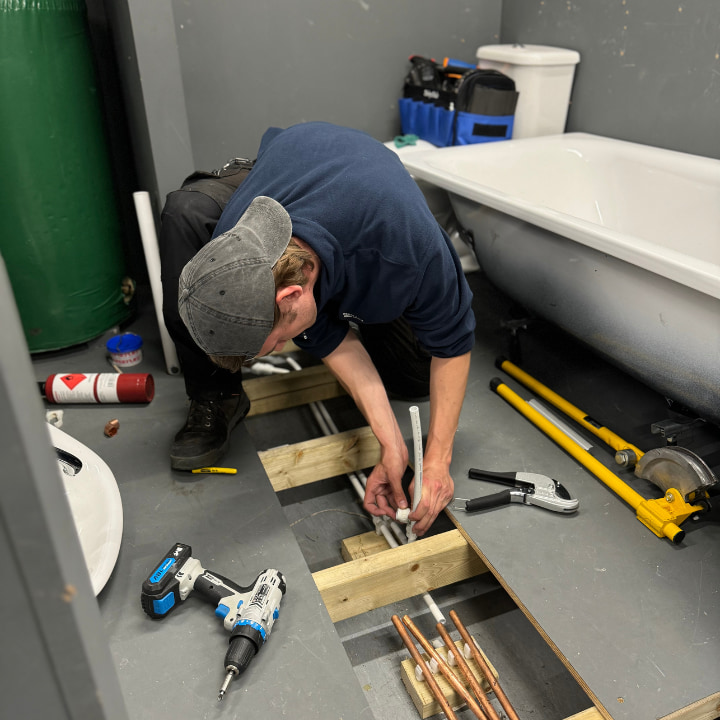Plumbing student working on some pipes
