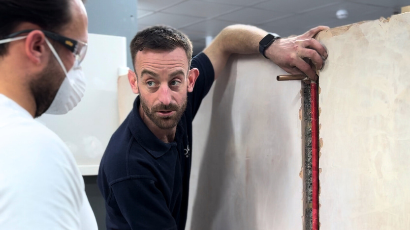 trainer showing how to place a pipe in a chased wall