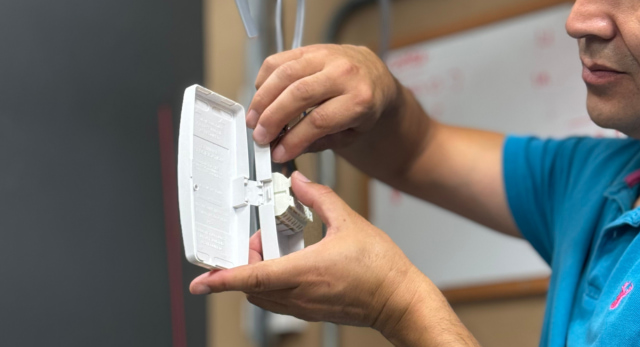 man completing an electrical job on a light junction box
