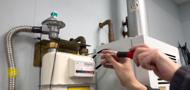person performing a tightness test on a gas meter