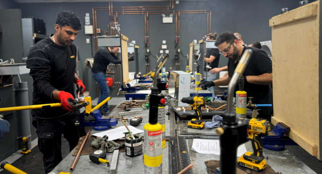 plumbing students completing their plumbing course in a workshop