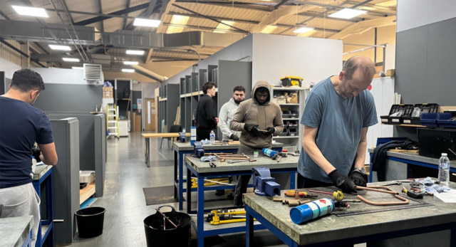 A group of people in a workshop training to be gas engineers and break the barriers to entering the trades