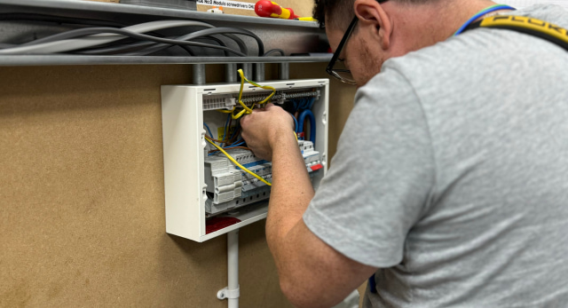 Electrical student training on an electrical box to become an electrician to earn money