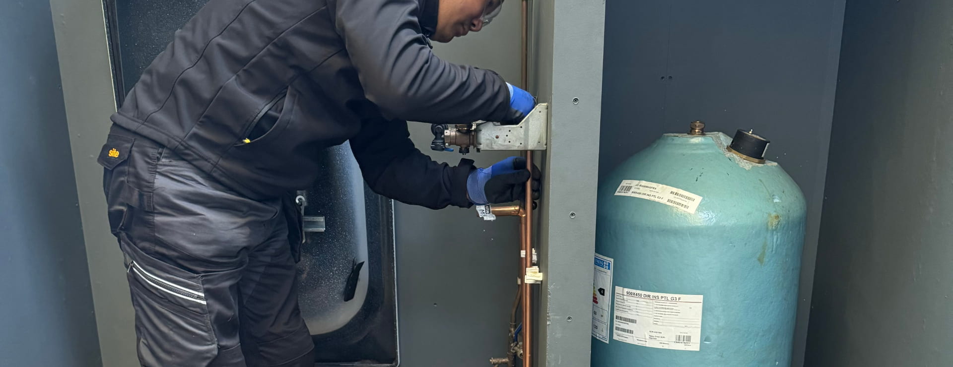 a plumbing student fitting pipe on a plumbing system to complete the job