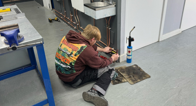 plumbing student completing one of their plumbing jobs to finish their training