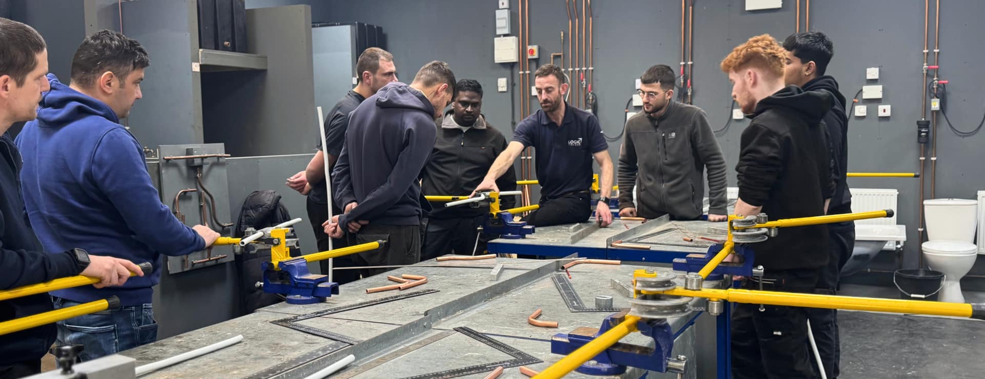 a plumbing trainer teaching a class of plumbing students who changed career to try and avoid ai job losses