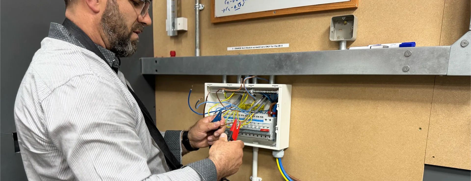 an electrical student testing a consumer unit after installing it