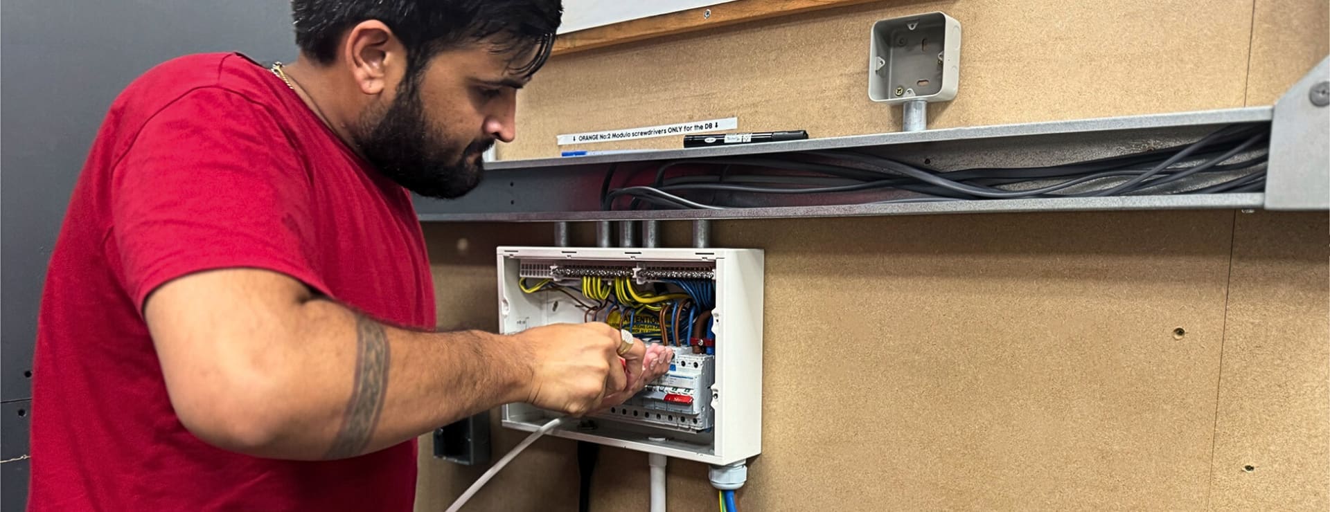 an electrical student installing an electrical consumer unit