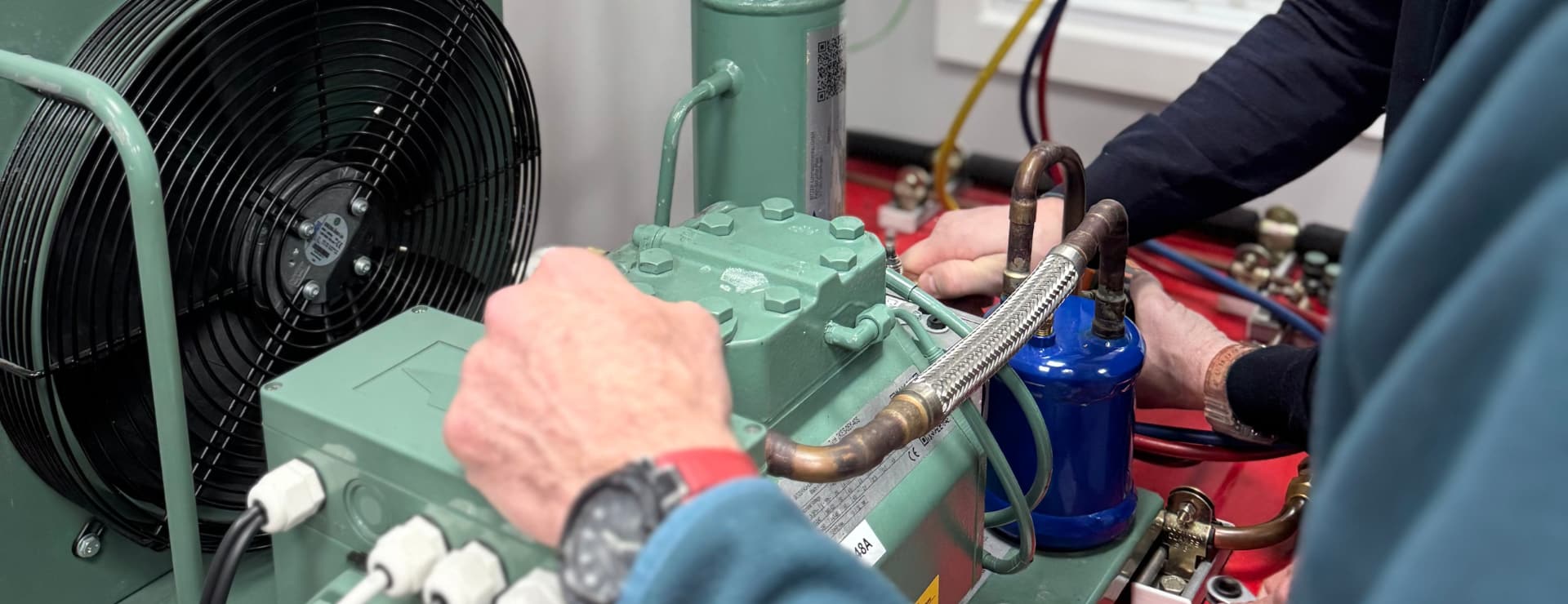 people working on a refrigeration system. Something that wont be affected by ai job losses