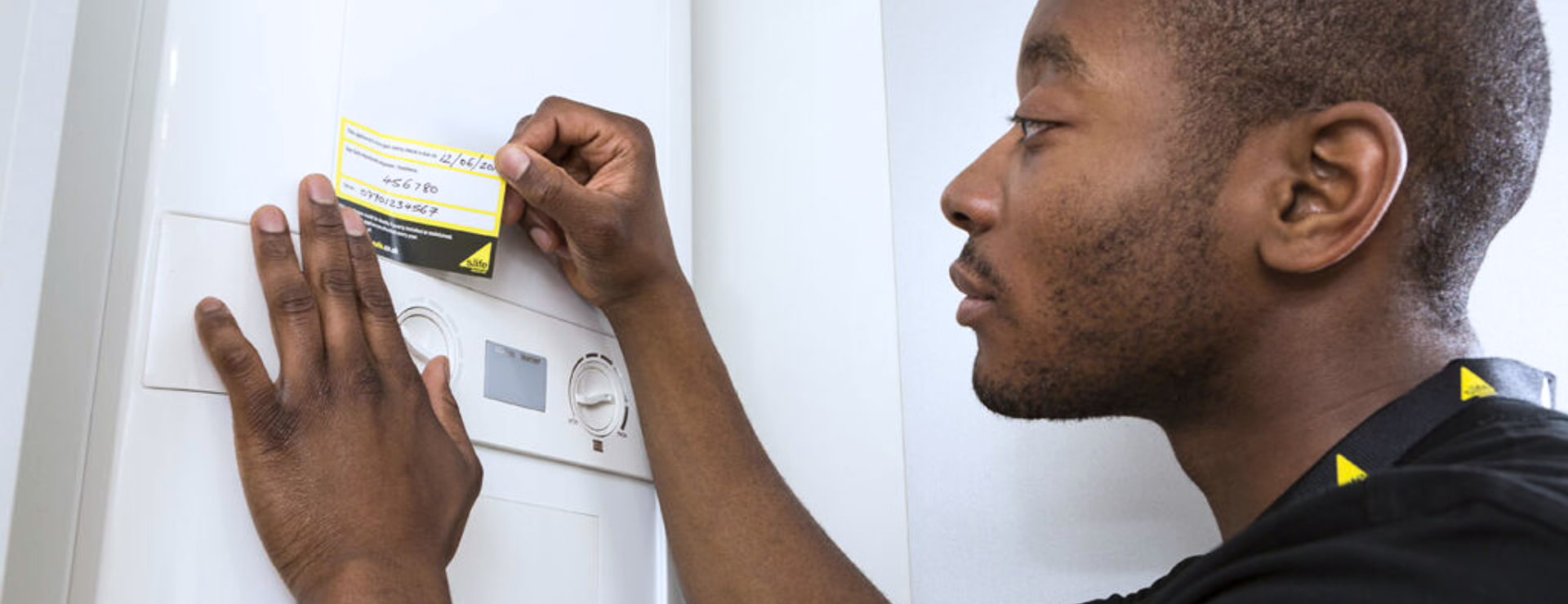 Gas engineer applying annual service sticker