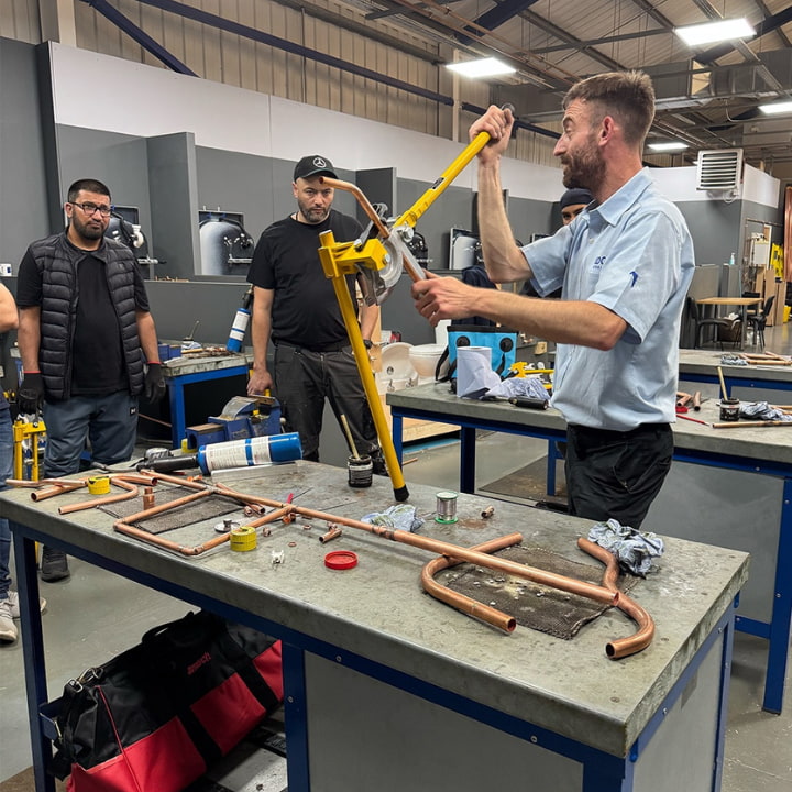 Logic4training teaching a class how to bend a copper pipe