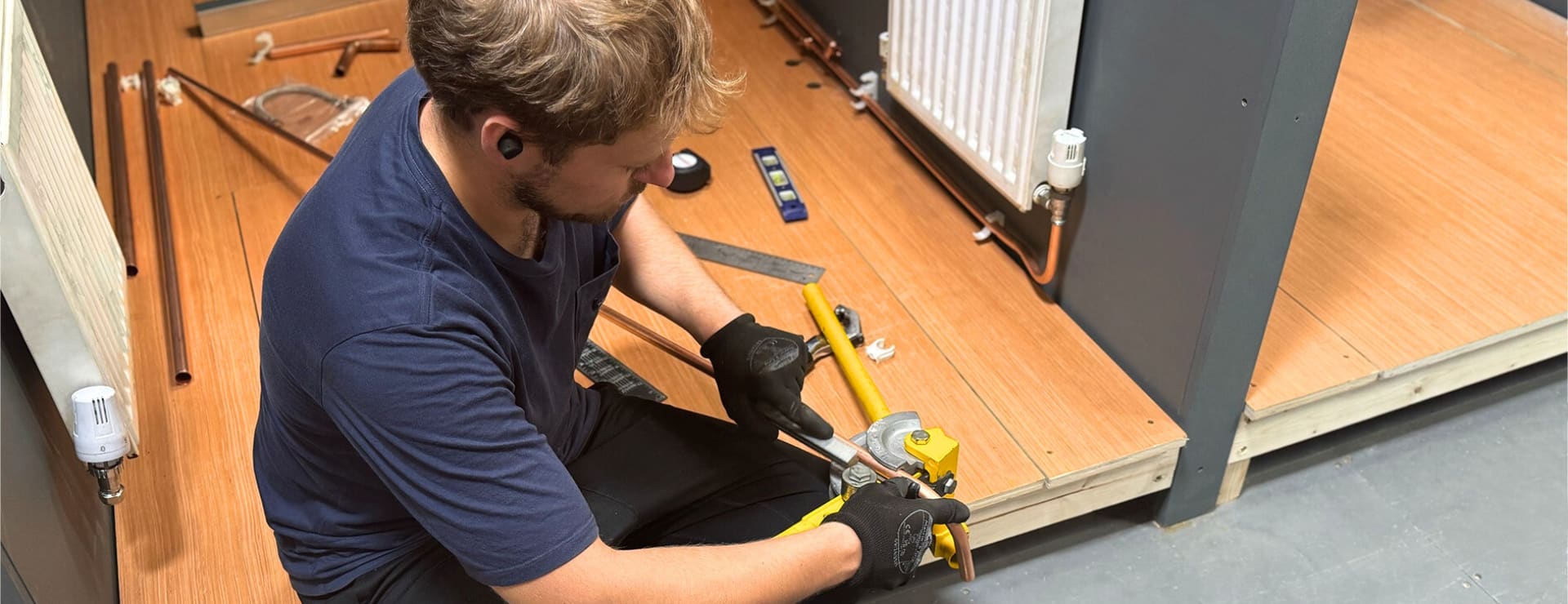 New entrant gas student bending a copper pipe to fit to a radiator and complete their gas MLP