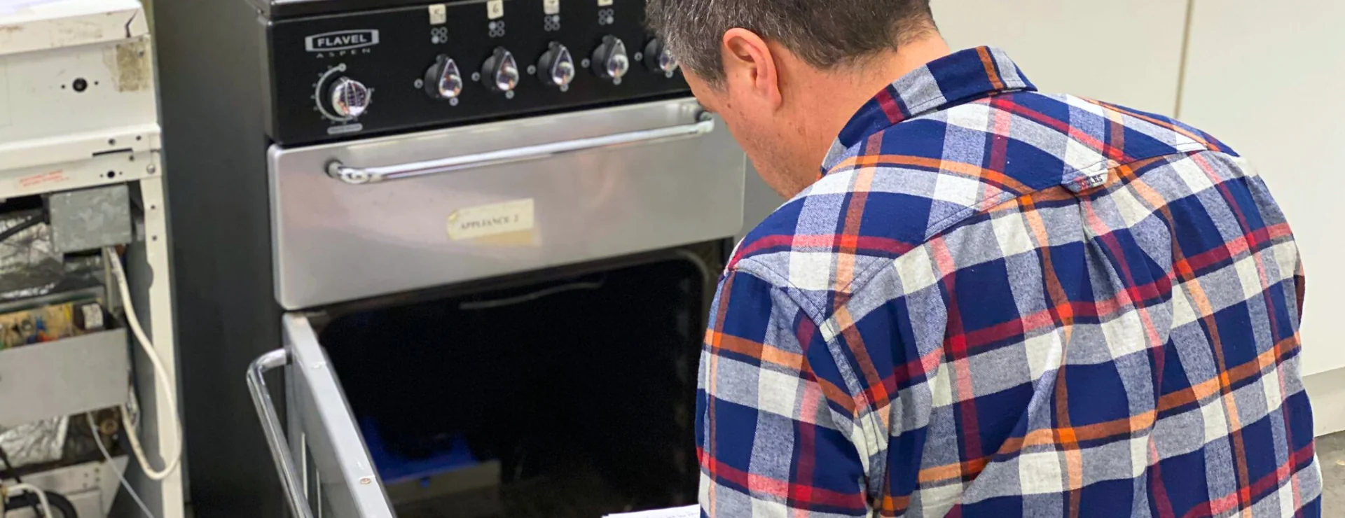 a gas engineer working on a gas cooker as part of their CCN1 reassessment course
