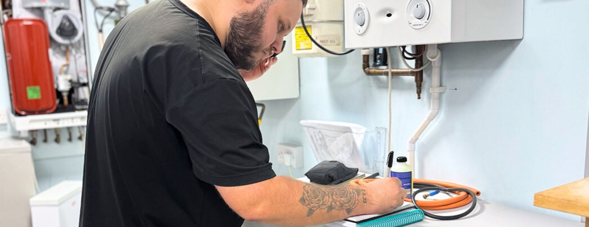 Logic4training gas apprentice working through their training manual to safely work on a boiler