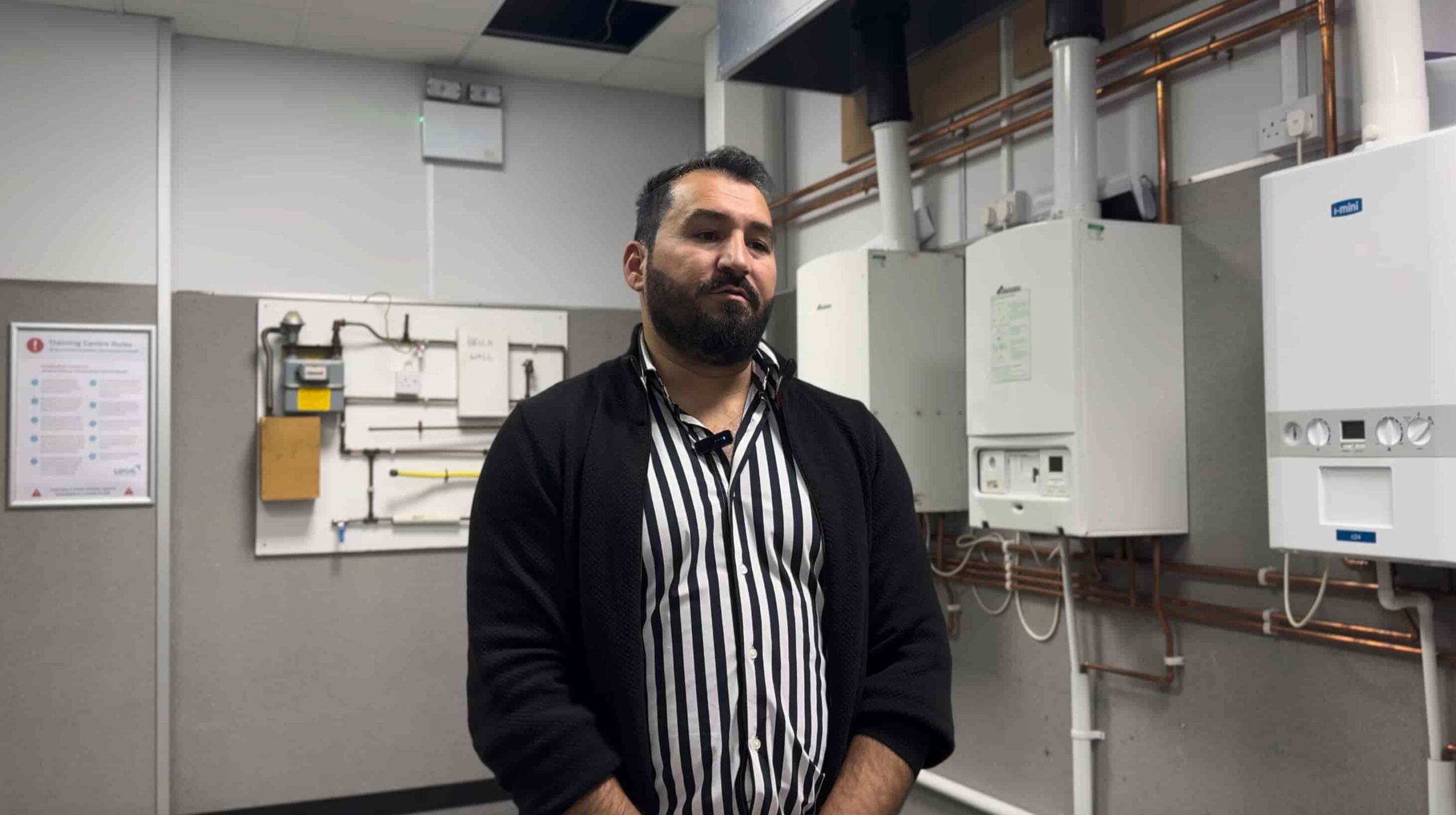 Niman stands in Gas Workshop in front of boilers