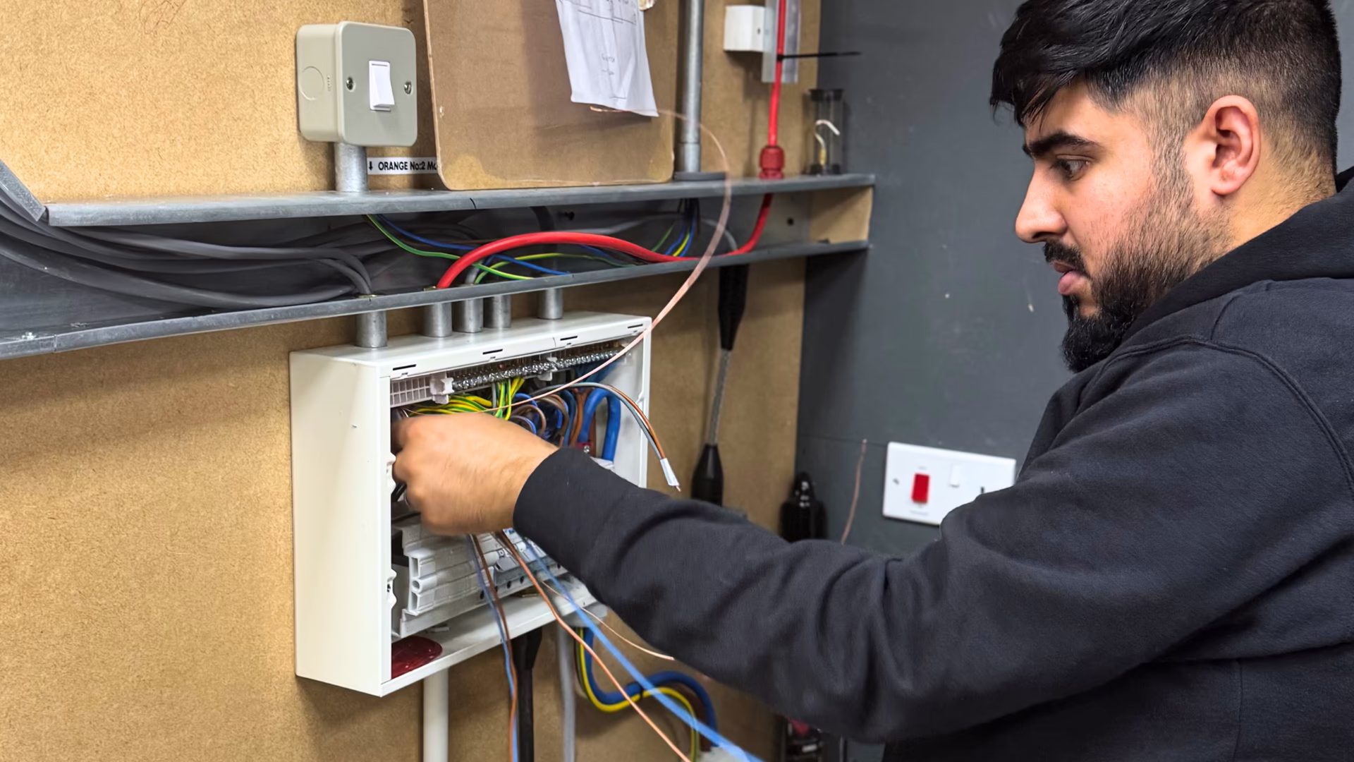 A Logic4training AM2 candidate working on a consumer unit