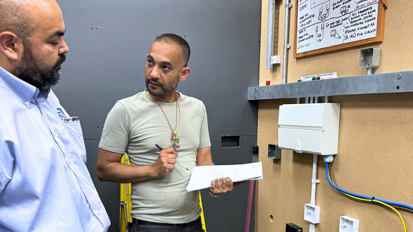 A Logic4training electrical student and trainer going through the requirements of environmental technology systems