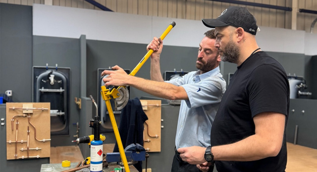 A Logic4training plumbing trainer with their student learning how to correctly bend copper pipe