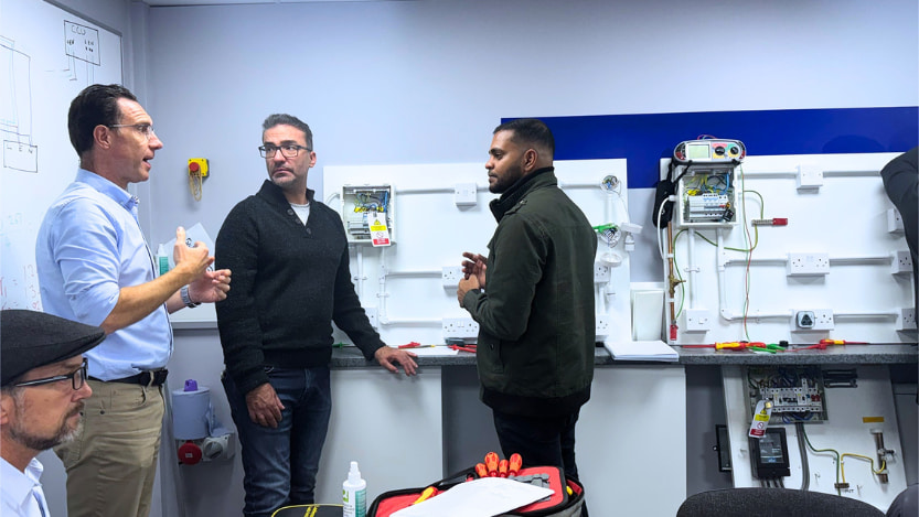A Logic4training 18th edition wiring regulations class where trainer with electrical students going through course content