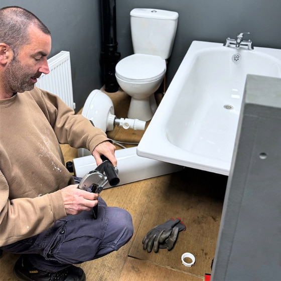 A Logic4training plumbing candidate cutting some waste pipe in their training bay