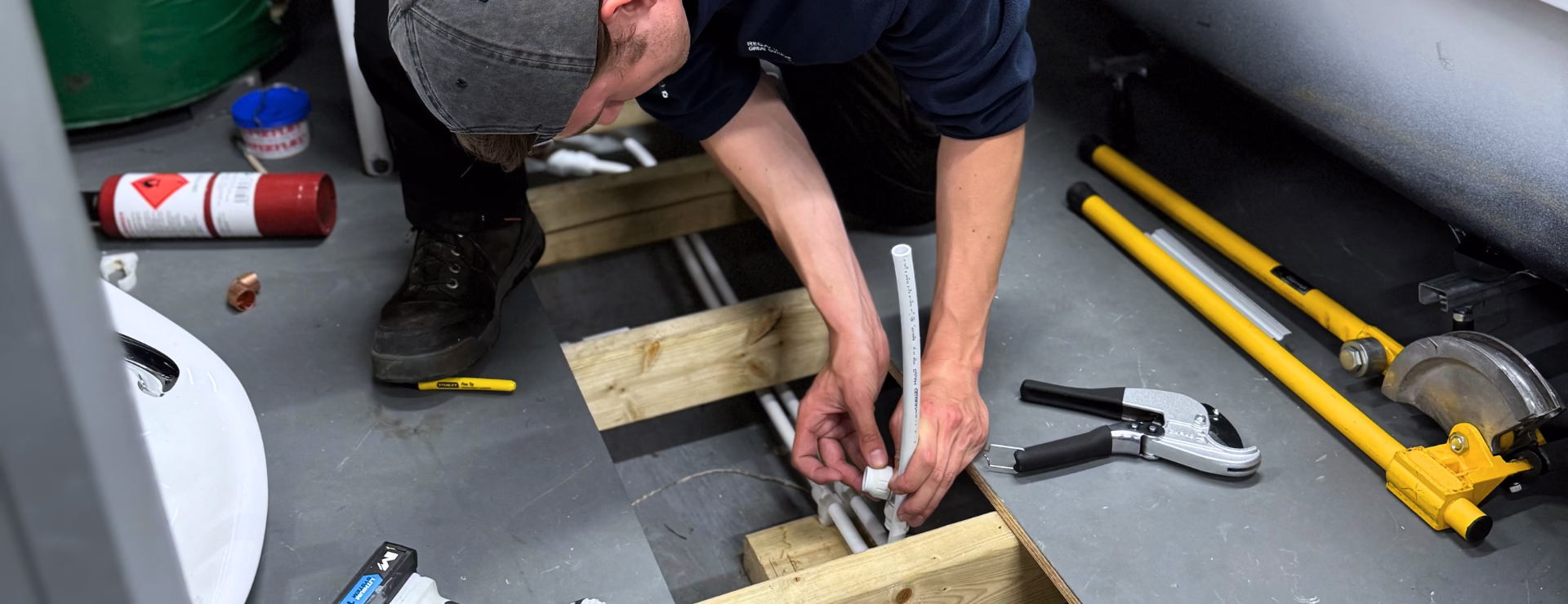A plumber completing the second fix of pipework