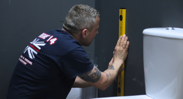 A plumber fitting a bathroom as part of their day to day work