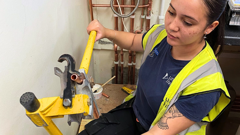 A plumbing NVQ candidate bending copper pipe to completing their portfolio with Logic4training