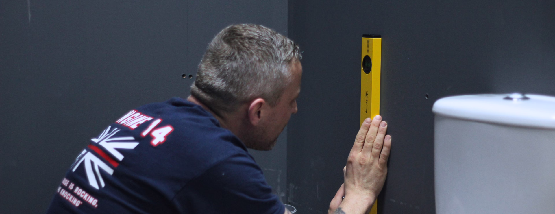 A Logic4training Level 2 Plumbing NVQ candidate using a spirit level on the wall