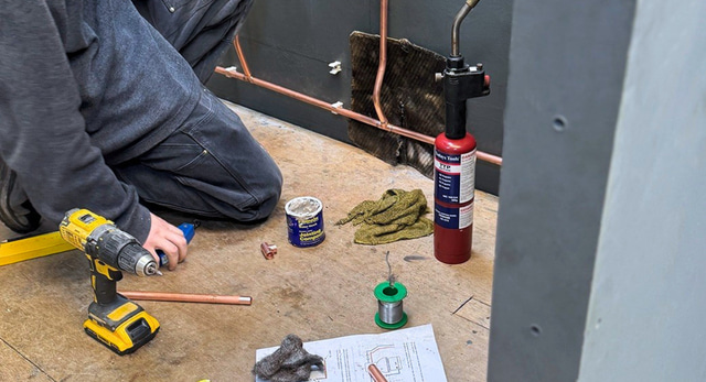 A plumber completing their plumbing training including WRAS to apply to WIAPS