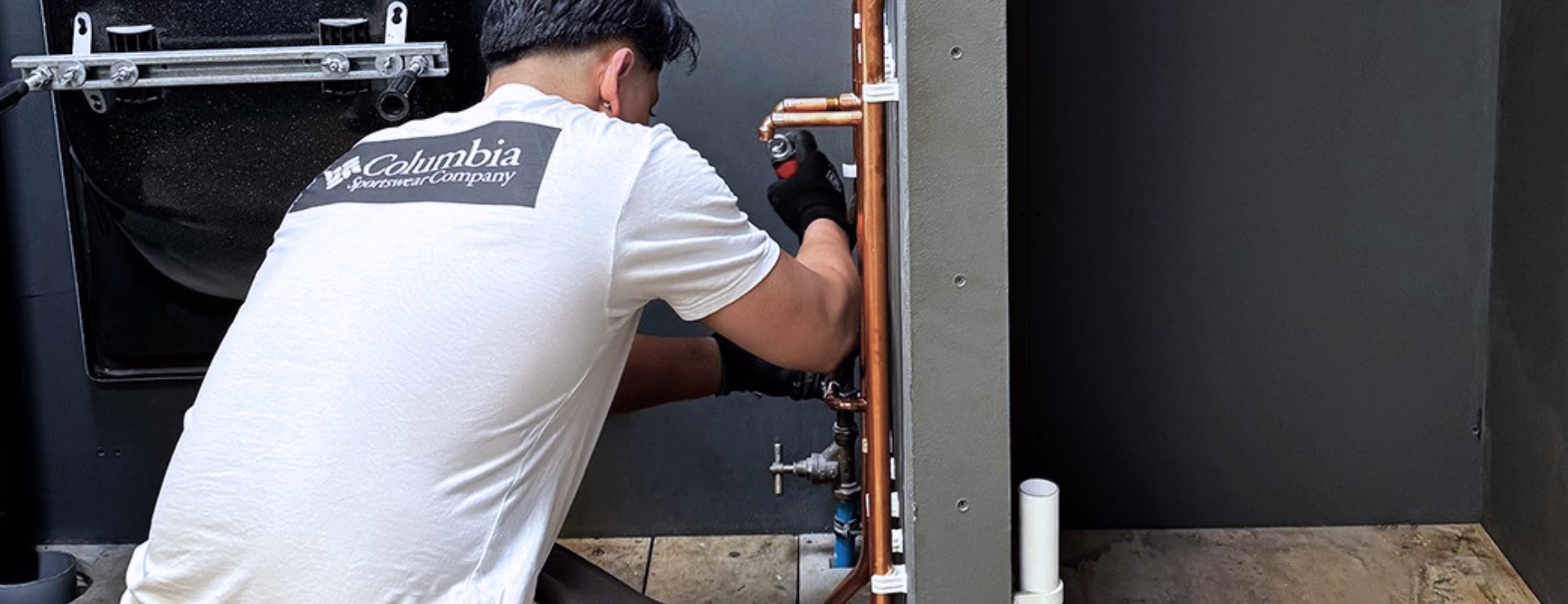 A plumbing student working on pipework as part of their WRAS approved plumbing training so that they can join WIAPS