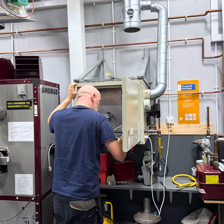 A commercial gas engineer working on an appliance as part of their commercial gas course