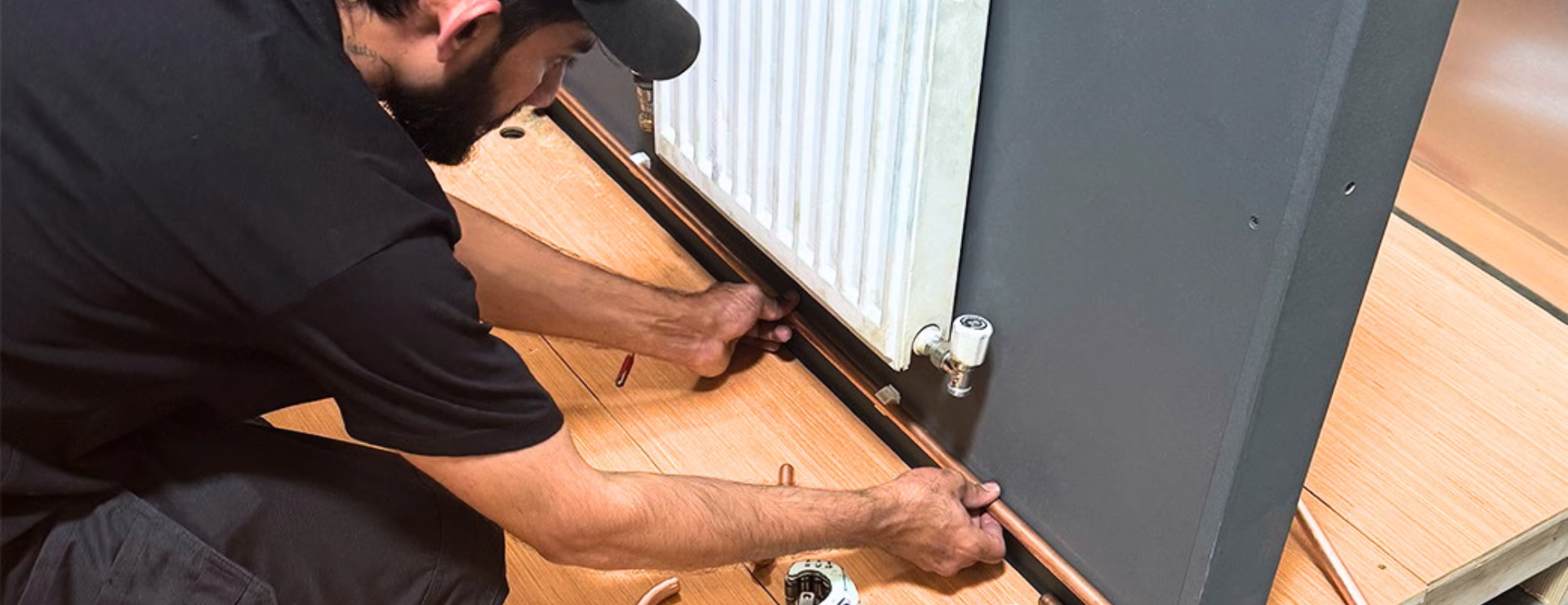 A man fitting copper pipe as part of their plumbing and heating training