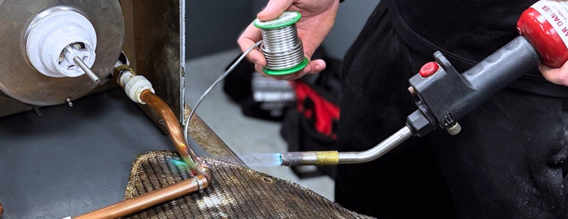 A trainee plumber soldering copper pipes