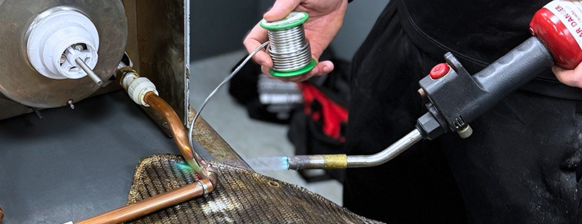 A trainee plumber soldering copper pipes