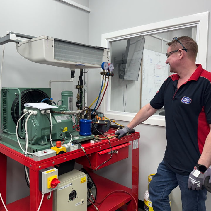 A man working on an f-gas air conditioning rig as part of his training