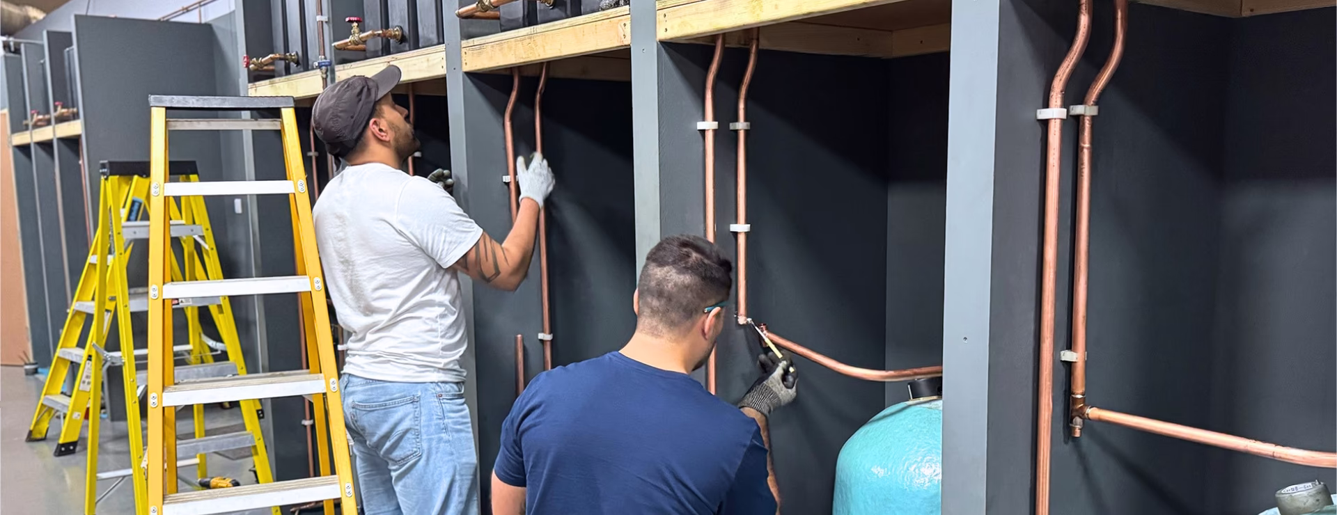 two men completing a plumbing course near London