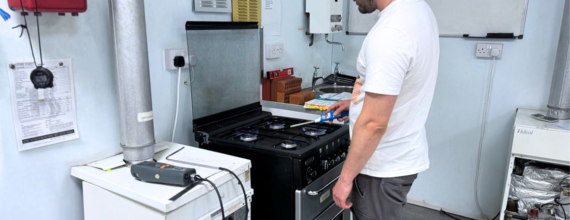 A man working on a gas cooker as part of their CKR1 gas appliance training