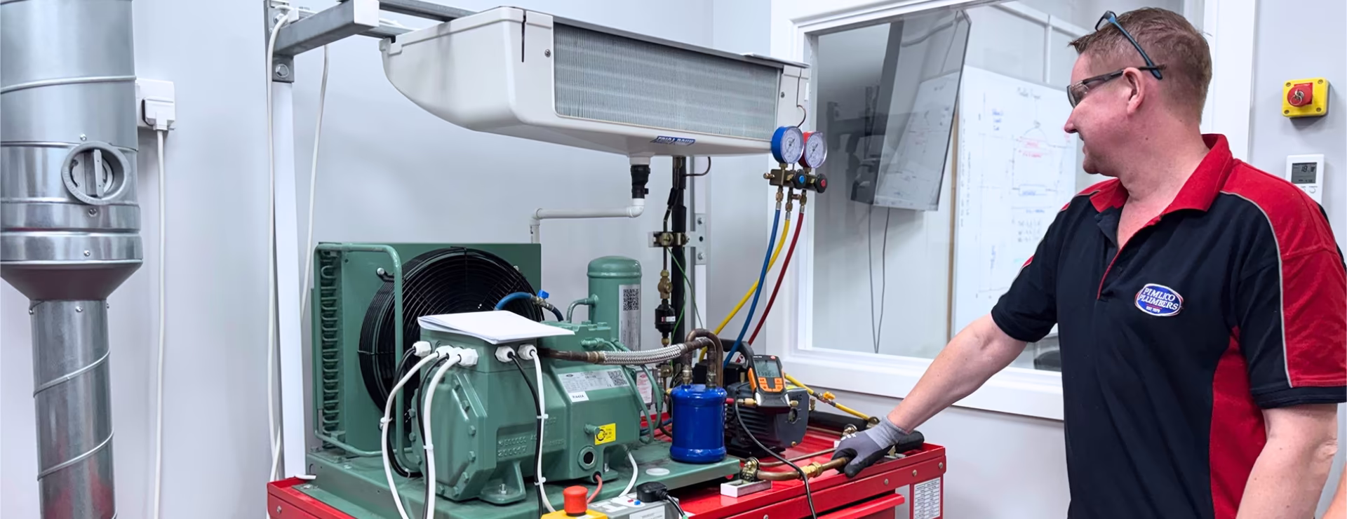 An F-Gas trainee working on an AC unit as part of their F-Gas training